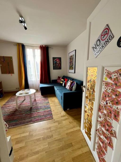 a living room with a blue couch and a table at F2 parking Gare in Melun