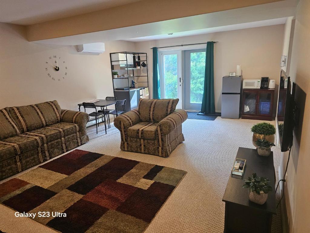 Una sala de estar con un sofá y sillas y una mesa. en Cozy, Private Basement Suite, en Halifax