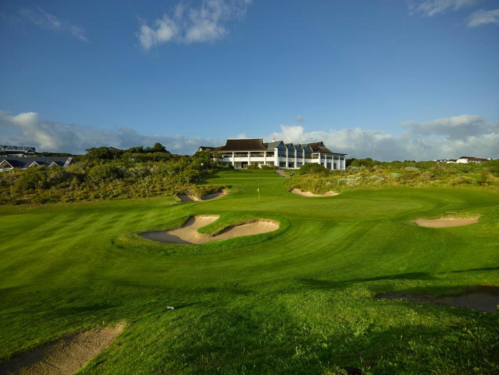 una vista aerea di un campo da golf con una casa sullo sfondo di St Francis Links - Villa Avenue Studio Apartments a St Francis Bay