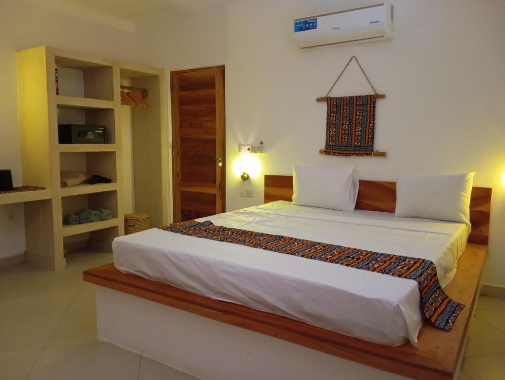 a bedroom with a large bed in a room at Aluna Beach House Nungwi in Nungwi