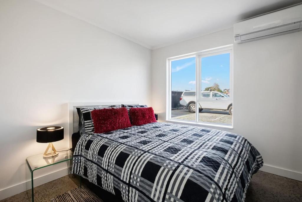 a bedroom with a bed and a window at Fly Around Town in Chic Retreat in Albion