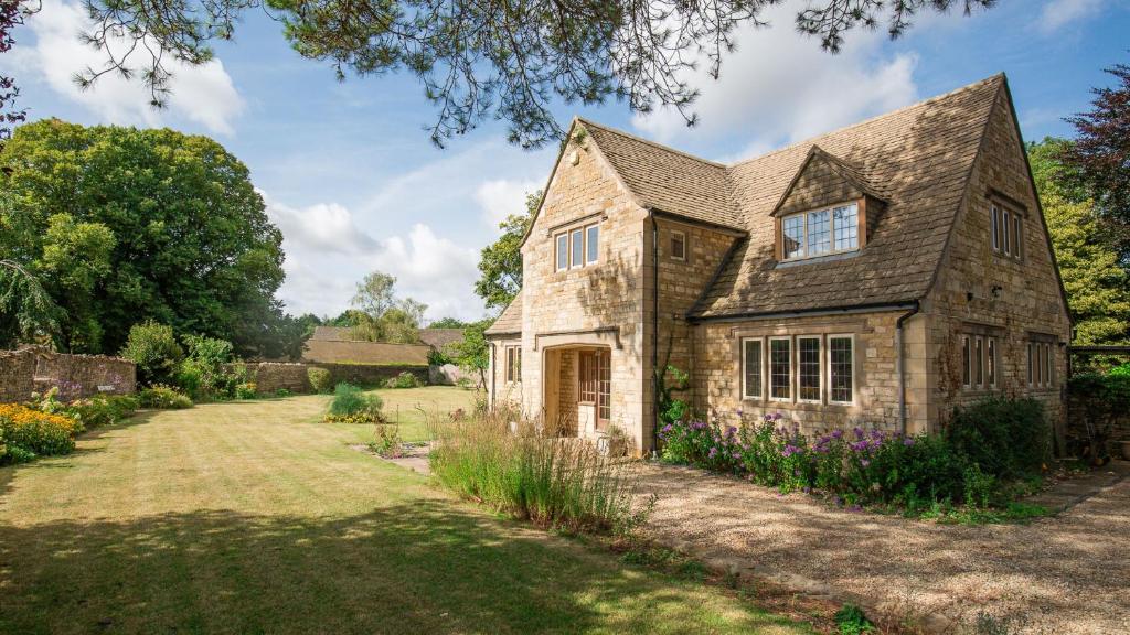 an old stone house with a yard at Arlington House in Lower Slaughter