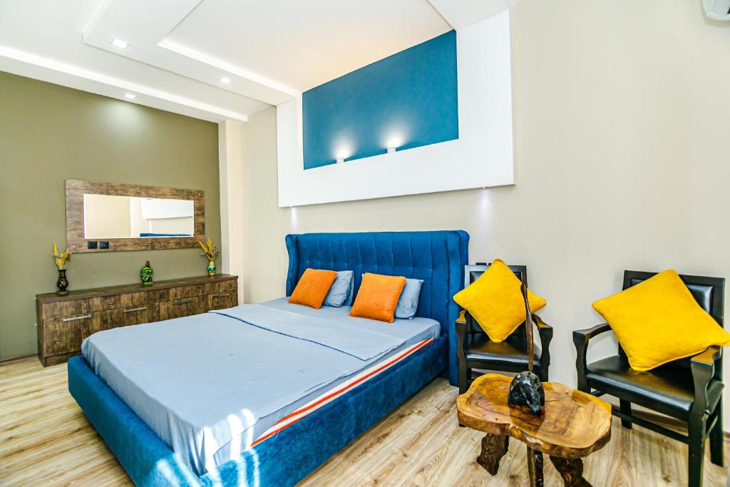 a bedroom with a blue bed and two chairs at Little Gem in the Old City - One Bedroom in Baku