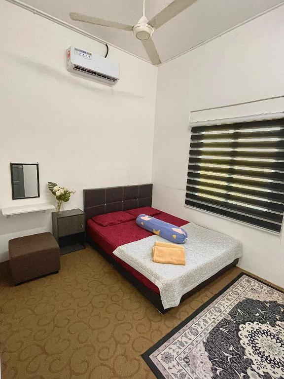 a bedroom with a bed and a window with avertisement at D'inaa Homestay Kota Bharu in Kota Bharu