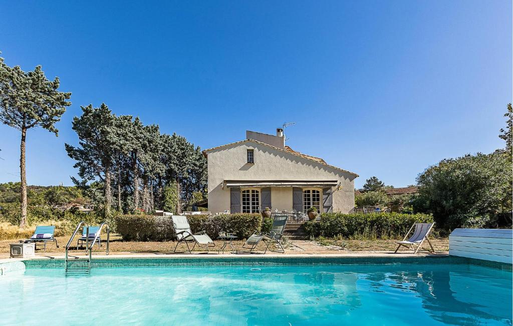 a house with a swimming pool with chairs and a house at 5 Bedroom Cozy Home In Laurens in Laurens