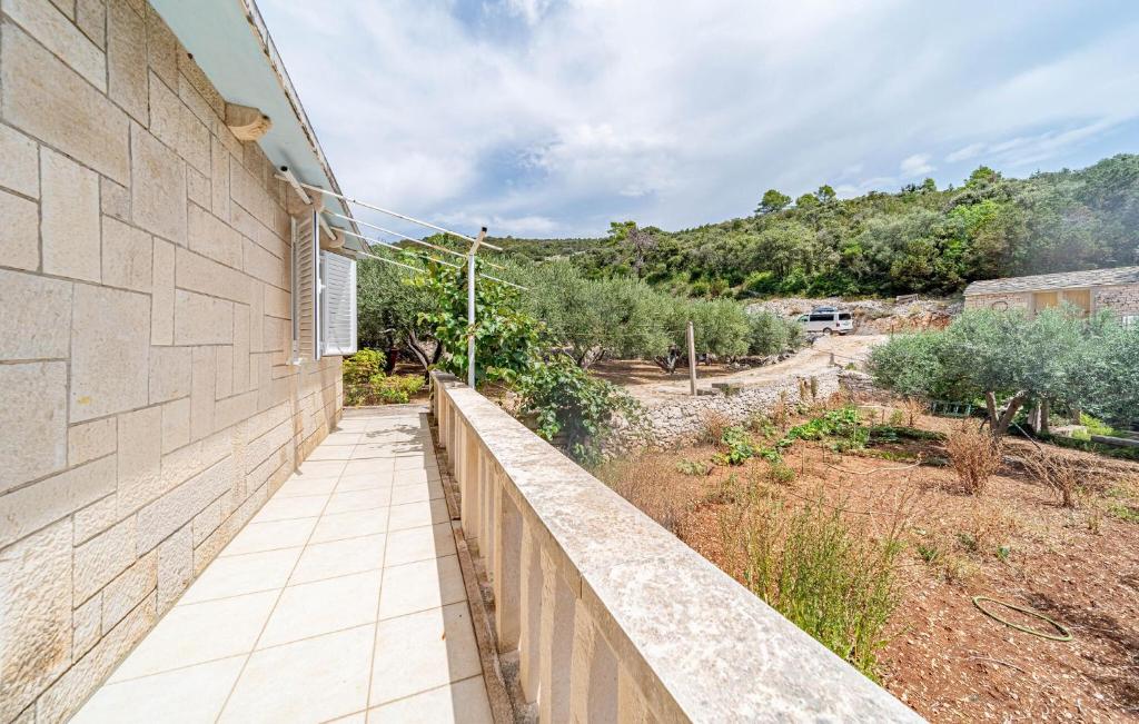 a stone wall with a walkway next to a field at Gorgeous Home In Zrnovo in Žrnovo
