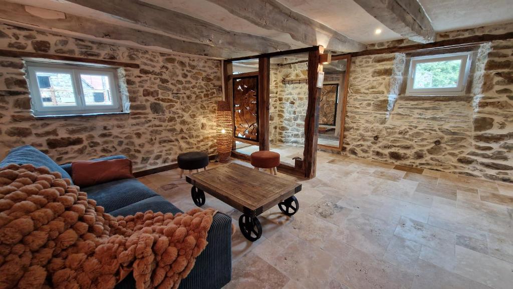 un salon avec un canapé et une table dans l'établissement Magnifique Maison Bretonne - Gîte Ar Baradoz, à Kergrist