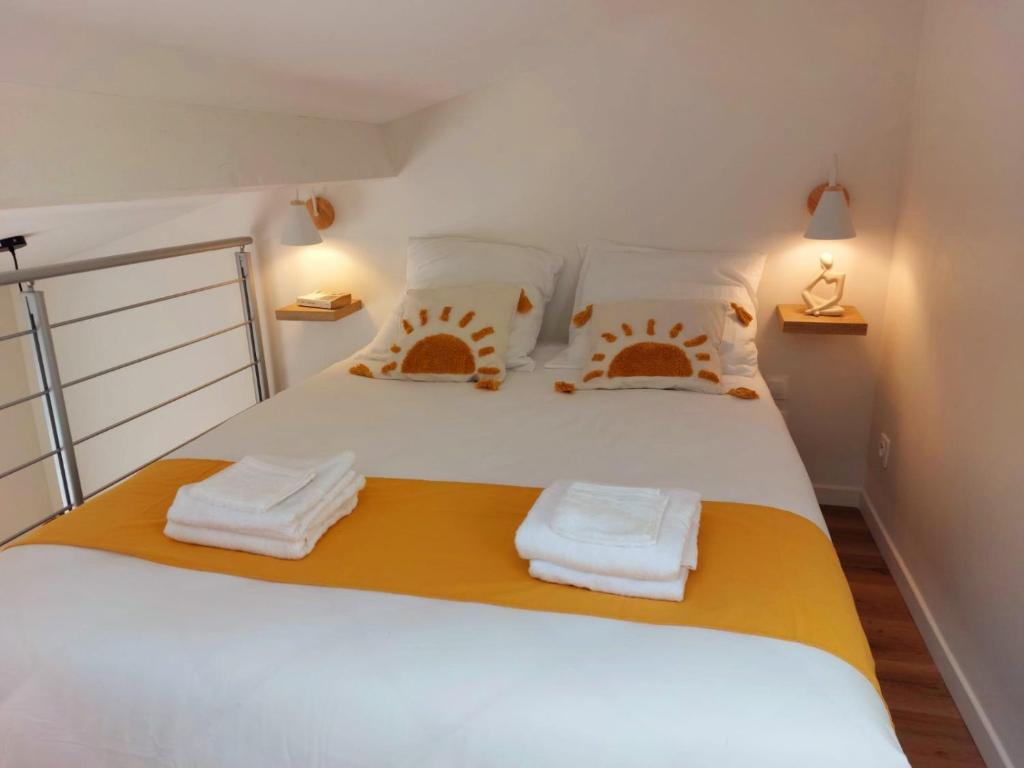 a bedroom with a white bed with towels on it at Charme, originalité, -1 minute Métro in Maisons-Alfort