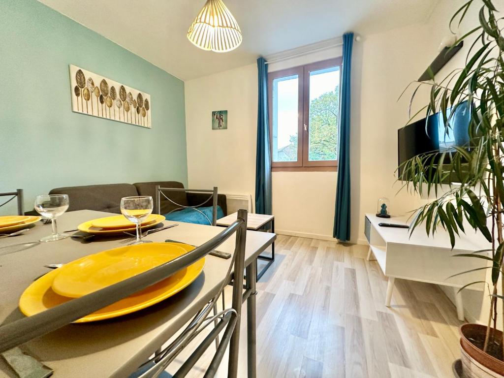 ein Esszimmer und ein Wohnzimmer mit einem Esstisch in der Unterkunft Le Guillaumin, convivial et zen in Limoges