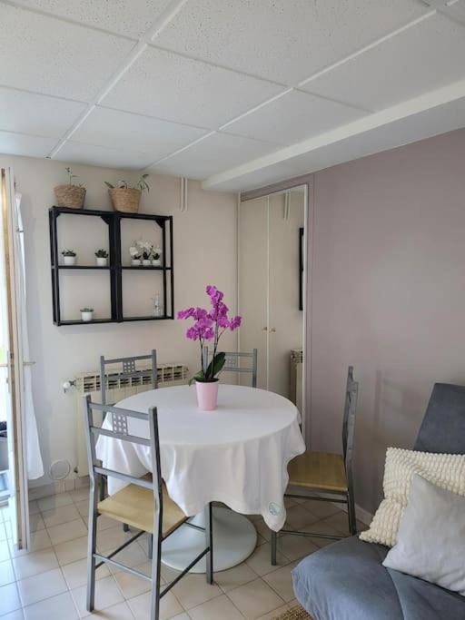 - une salle à manger avec une table ornée de fleurs violettes dans l'établissement Charmant appartement 35 m2 avec terrasse et jardin, à Domont
