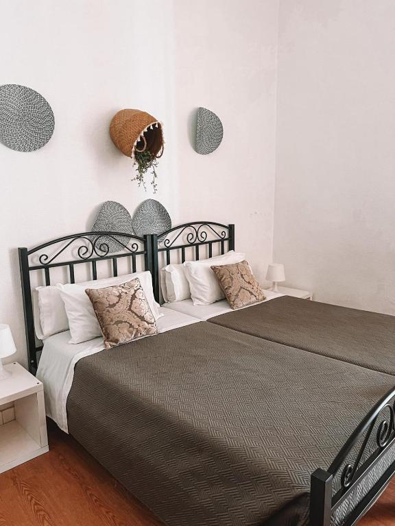 a bedroom with a black and white bed with pillows at Avis Guesthouse in Évora