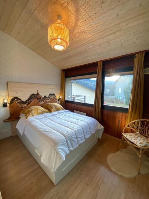 une chambre avec un grand lit avec un plafond en bois dans l'établissement Appartement 4-6 pers - La Bourboule, à La Bourboule