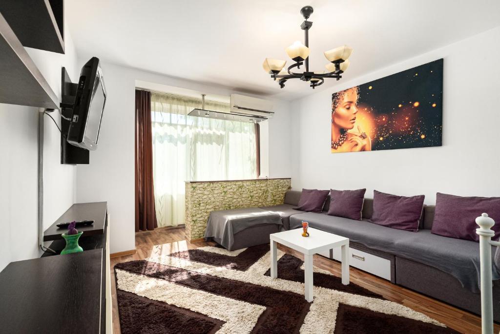 een woonkamer met een bank en een tv bij Stone Gate Apartment #2 in Boekarest