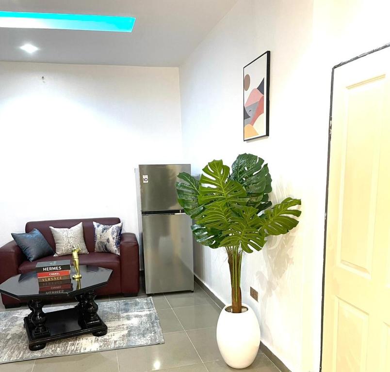 a living room with a couch and a potted plant at Wine House, Maitama, Abuja in Abuja