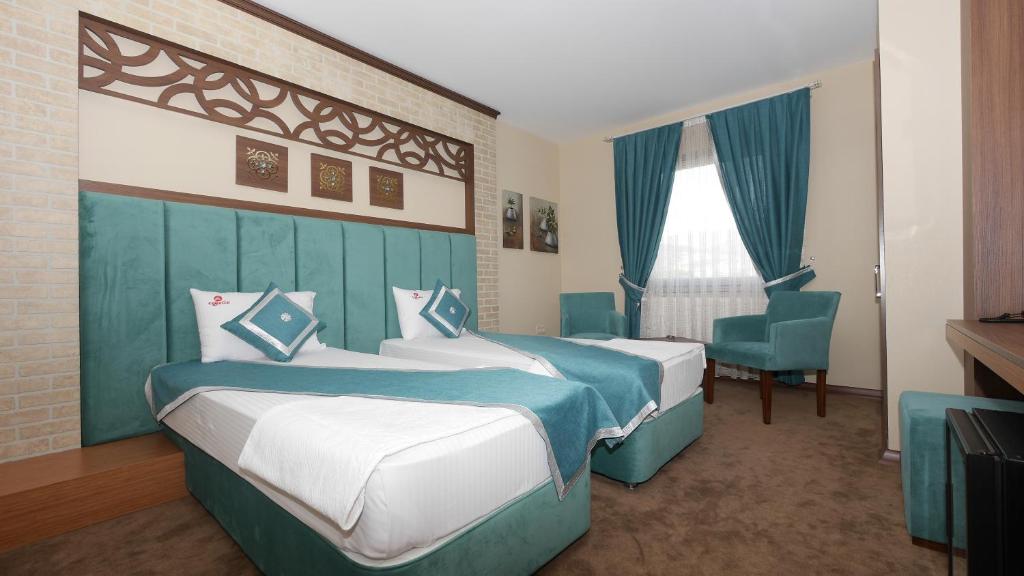 a hotel room with two beds and a chair at Hotel Labella Bergama in Bergama
