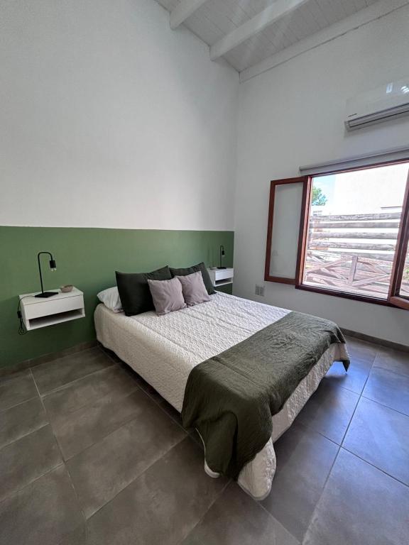 a bedroom with a large bed and a window at Casa Cielo in San Antonio de Areco