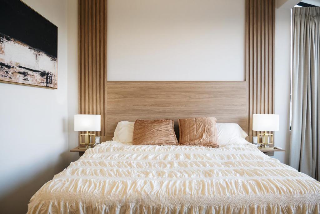 a bedroom with a large bed with two lamps at Casa Lomas in Oaxaca City