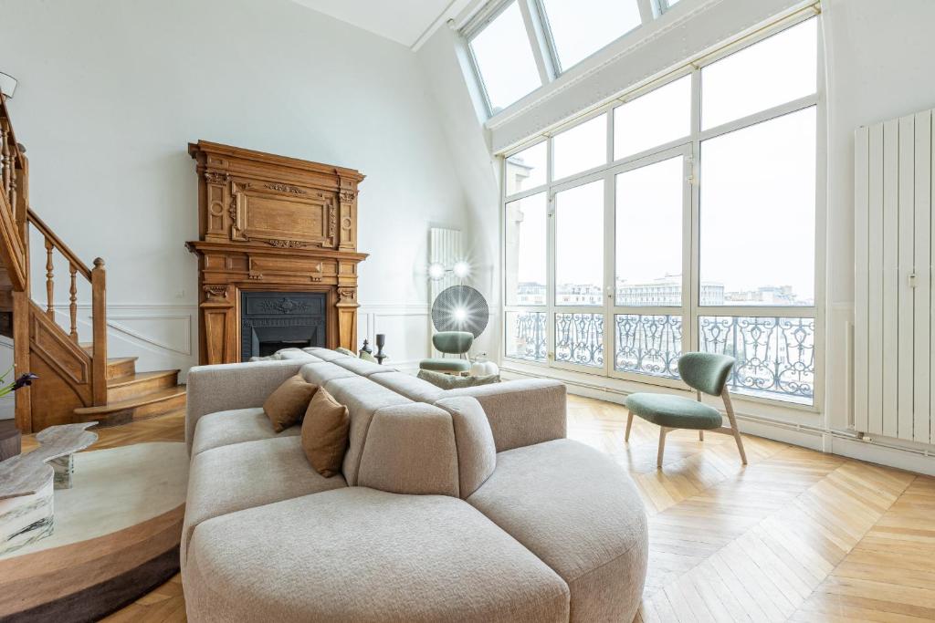 un salon avec un canapé et une cheminée dans l'établissement Luxueux Appartement 4BD, Arc de Triomphe, à Neuilly-sur-Seine