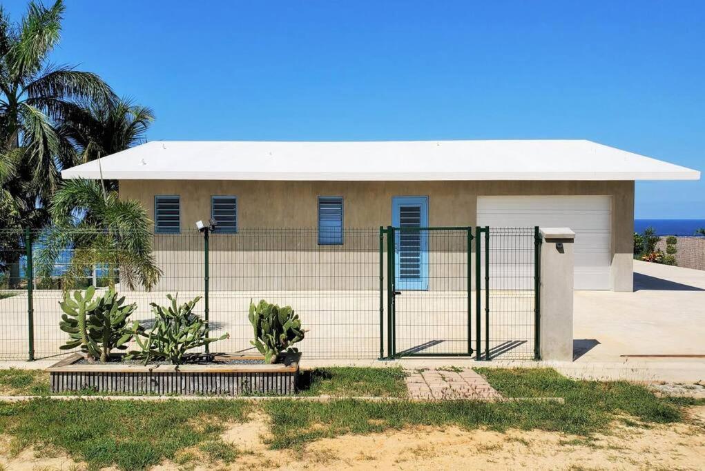 a house with a fence in front of it at Experience mesmerizing views at The Cliff House from your private plunge pool in Aguadilla