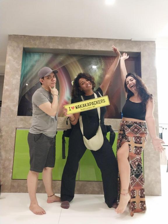 a group of people standing in front of a painting at WakakaPackers in Kuala Lumpur