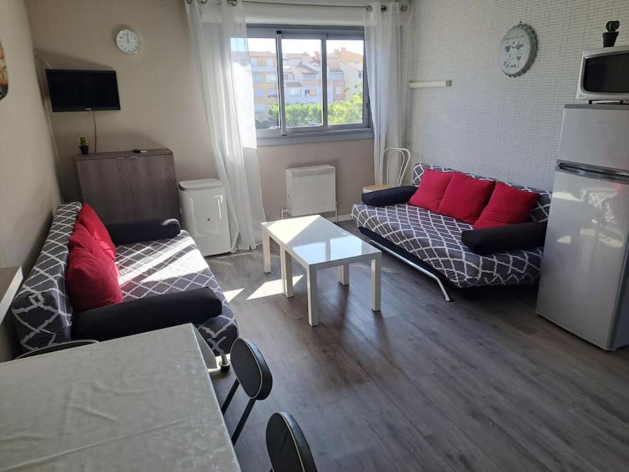 un soggiorno con due divani e un tavolo di Asphodèle, Joli studio avec parking, 2 pas des plages et du Port a Cap d'Agde