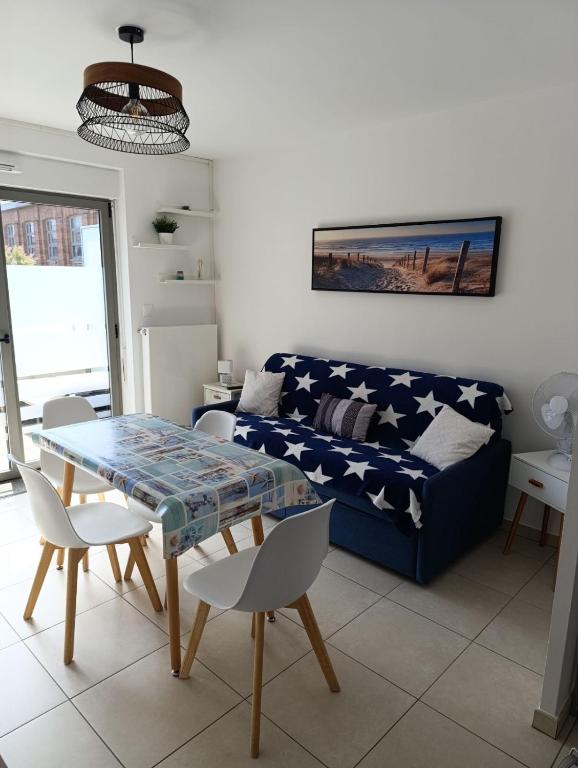 un salon avec un canapé et une table dans l'établissement En bord de mer, à Berck-sur-Mer