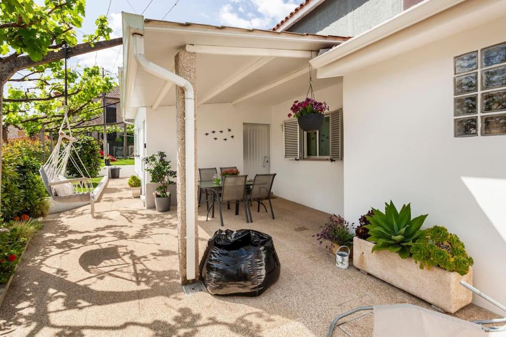 a patio of a white house with a black bag at Casa do Fontanário in Penafiel
