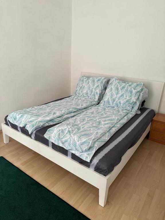 维也纳A place to relax的一张未整理的床，上面铺着一条蓝色的毯子