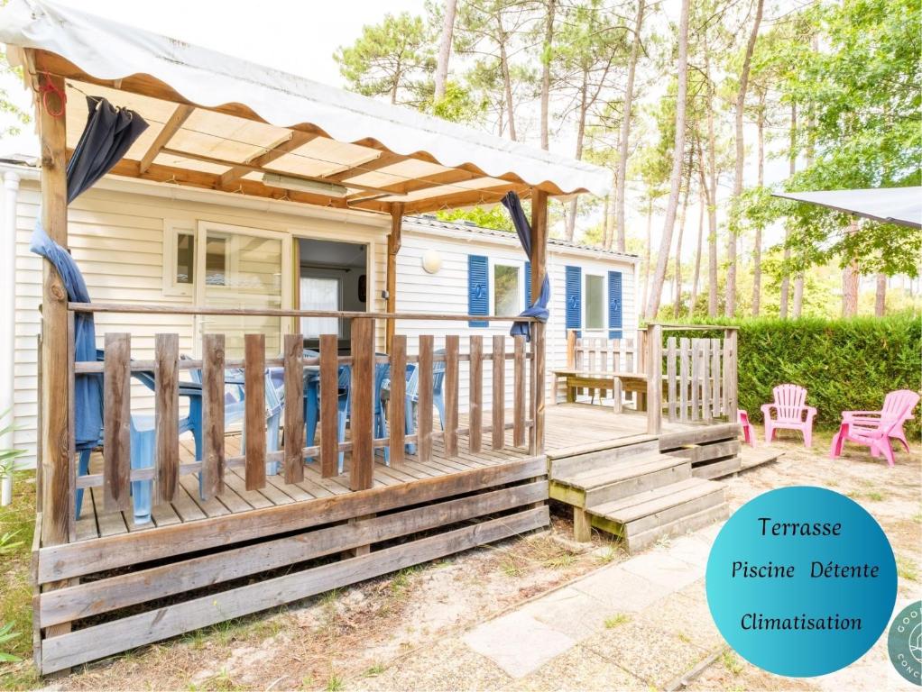 une petite maison avec une terrasse et une pergola dans l'établissement Petit cocon ensoleillé, le mobil-home Alélé, à Bias