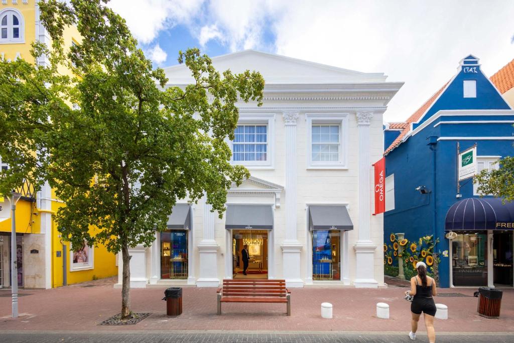 una mujer caminando frente a un edificio en Broadway Apartments - Chic & Stylish Urban Stays, en Willemstad