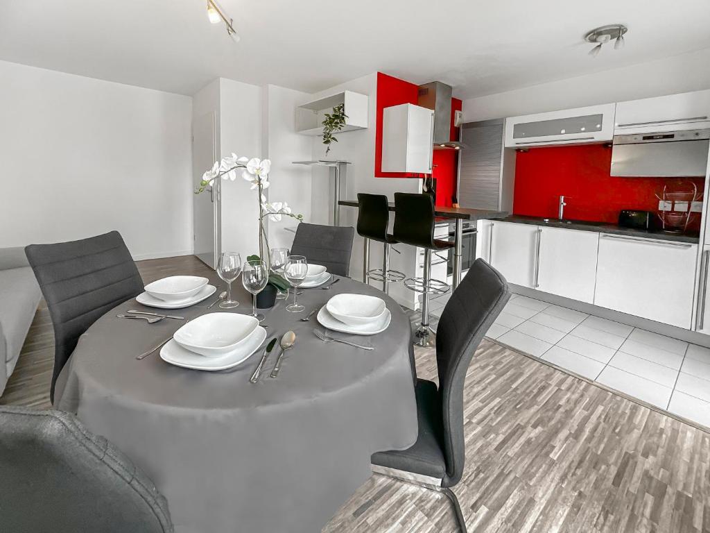 a dining room table with chairs and a kitchen at Balcon privé, parking gratuit, Orly 5 kms in Villejuif