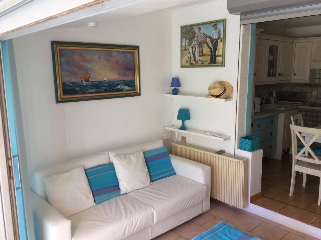 un salon avec un canapé blanc et une cuisine dans l'établissement Carro, aux couleurs de la Méditerranée, à Martigues