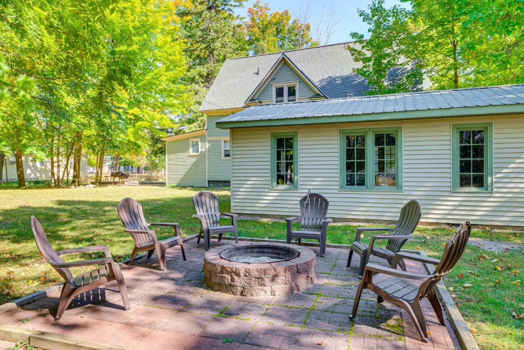 a group of chairs around a fire pit in front of a house at Near Lake Historic Boyne City Home with Fire Pit! in Boyne City