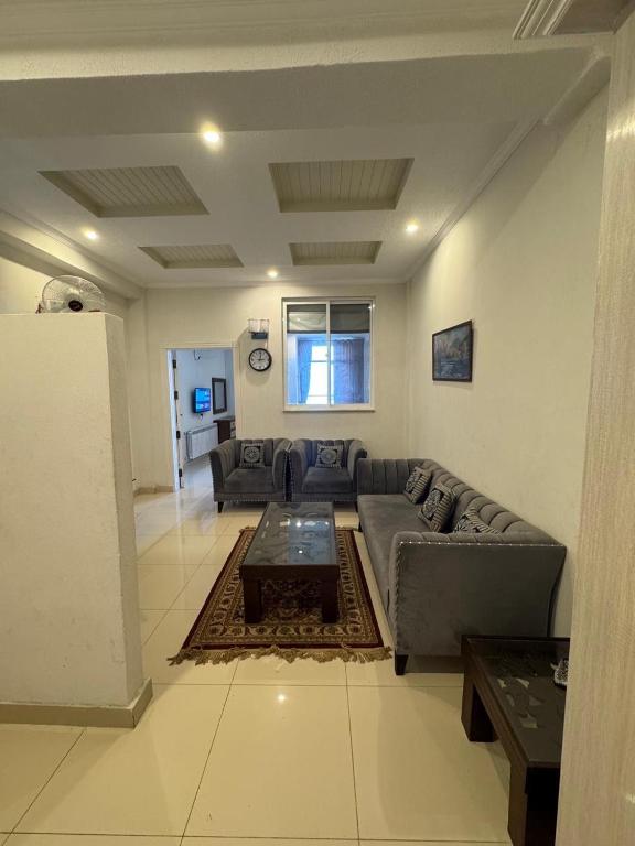 ein Wohnzimmer mit Sofa und Tisch in der Unterkunft Serenity Suites in Bhurban