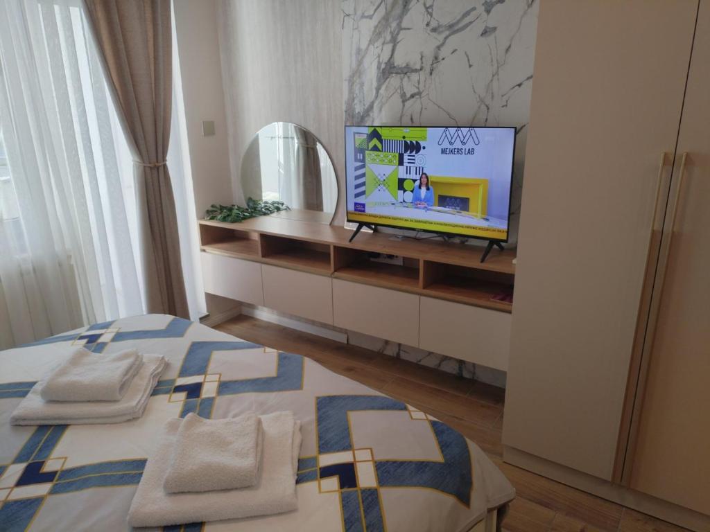a bedroom with a bed and a tv on a shelf at Apartment Centrum - Free private parking in Novi Sad