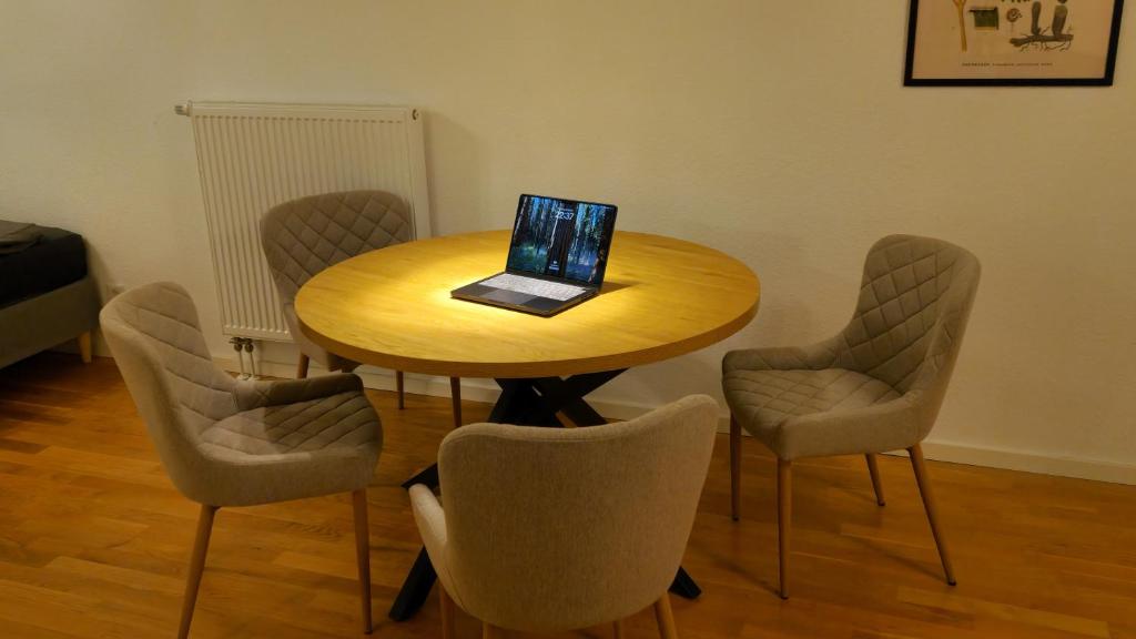 ヴェルネ・アン・デア・リッペにあるModerne, barrierefreie Wohnung im Herzen der Stadt mit Parkplatz, WLAN und TV - Martaの木製のテーブルと椅子、そしてノートパソコン