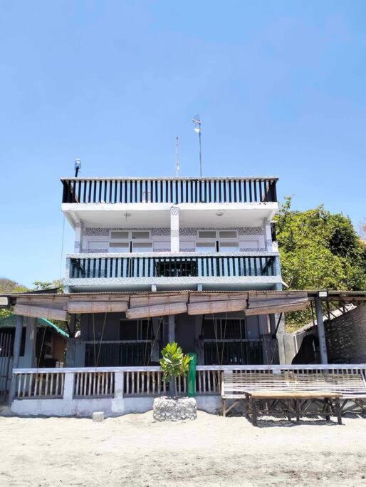 a building with two benches in front of it at Caleboat Beach Resort in Kalooñgan