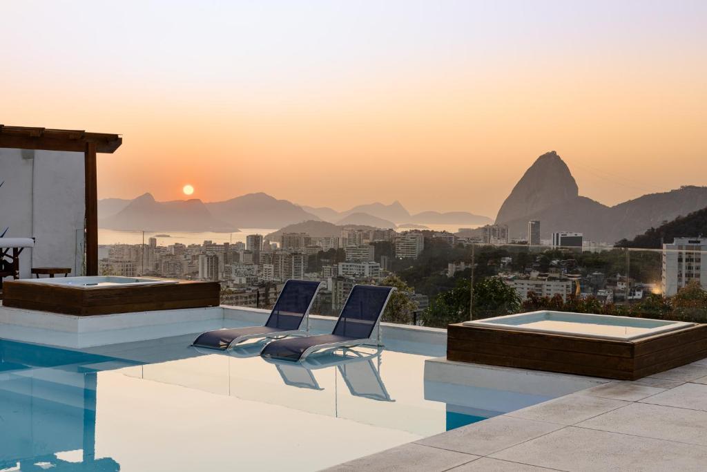 a pool with two chairs and a view of the city at Santa Vista Rio in Rio de Janeiro