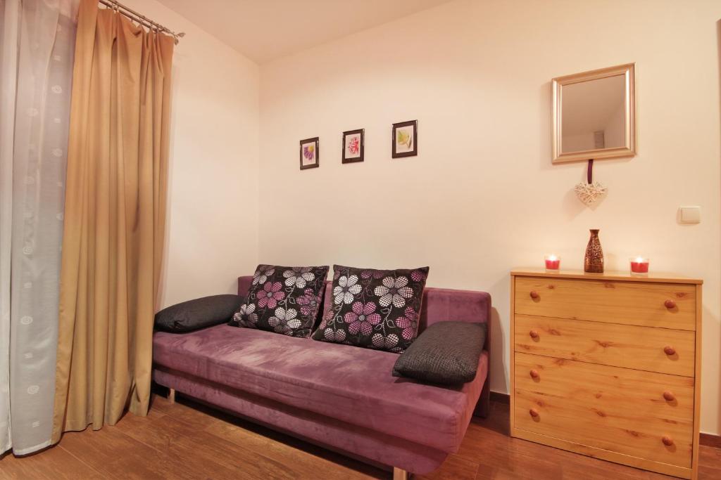 ザコパネにあるApartSerwis - Apartment U Sabały Centrumの紫色のソファとドレッサー付きのリビングルーム