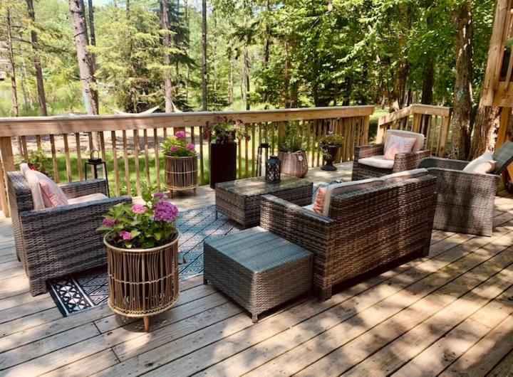 una terrazza in legno con tavolo e sedie in vimini di Majestic Lake Front Chalet a Tobyhanna