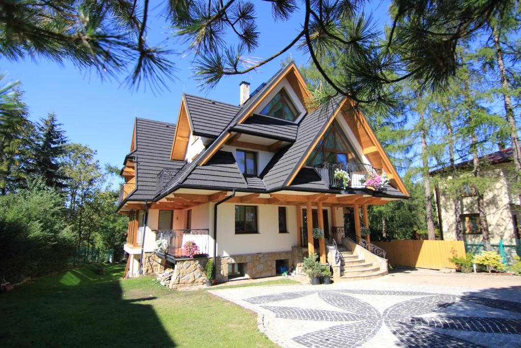 une maison avec un toit en gambrel dans l'établissement Wilcznik 10, à Zakopane