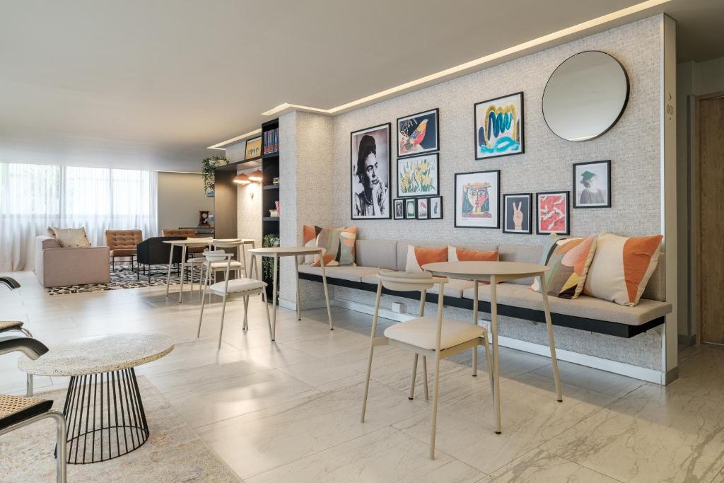 a living room with a couch and tables at District Polanco by Lumina in Mexico City