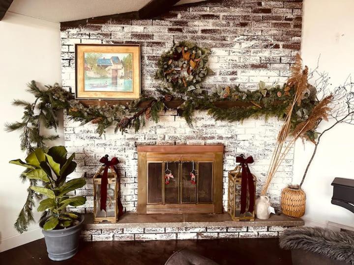 un camino con corone di Natale su un muro di mattoni di Majestic Lake Front Chalet a Tobyhanna