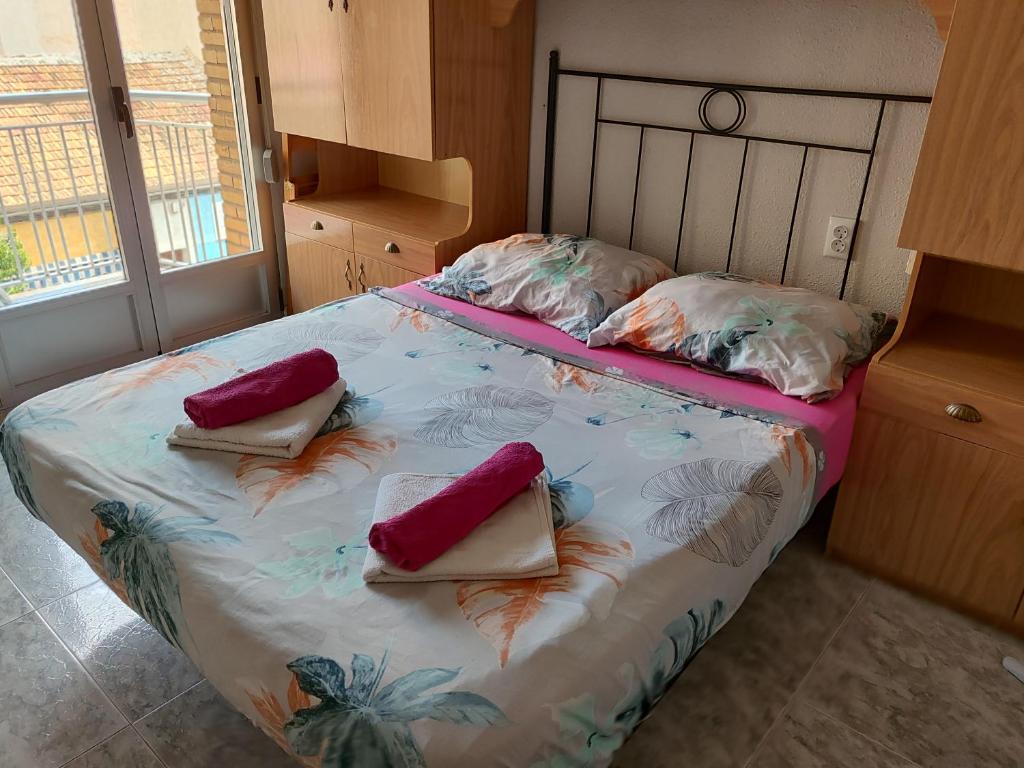 Un dormitorio con una cama con almohadas encima. en Apartamento Acequion, en Torrevieja