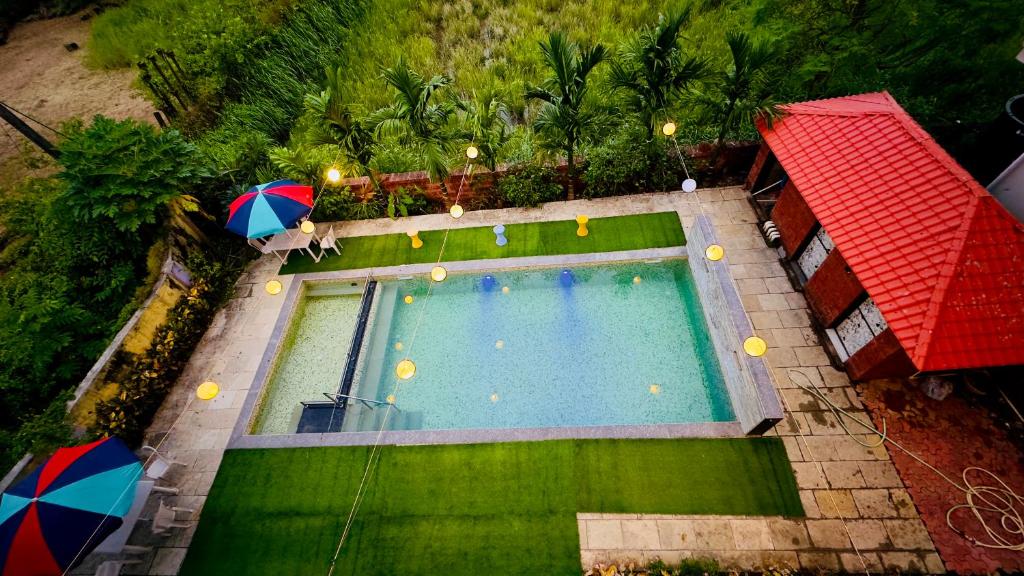 an overhead view of a swimming pool with an umbrella at Kashid Sunrise Resort in Kashid
