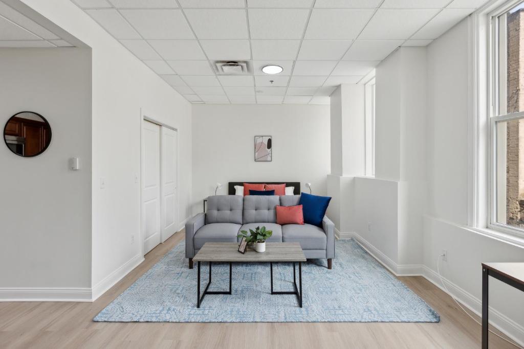 a living room with a couch and a table at East 225 I Modern Studio In Downtown Rochester in Rochester