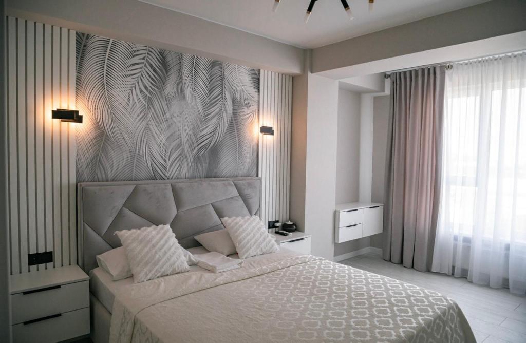 a bedroom with a large bed and a large window at Tulip Residence & Rent Burebista Lux Apartament in Chişinău