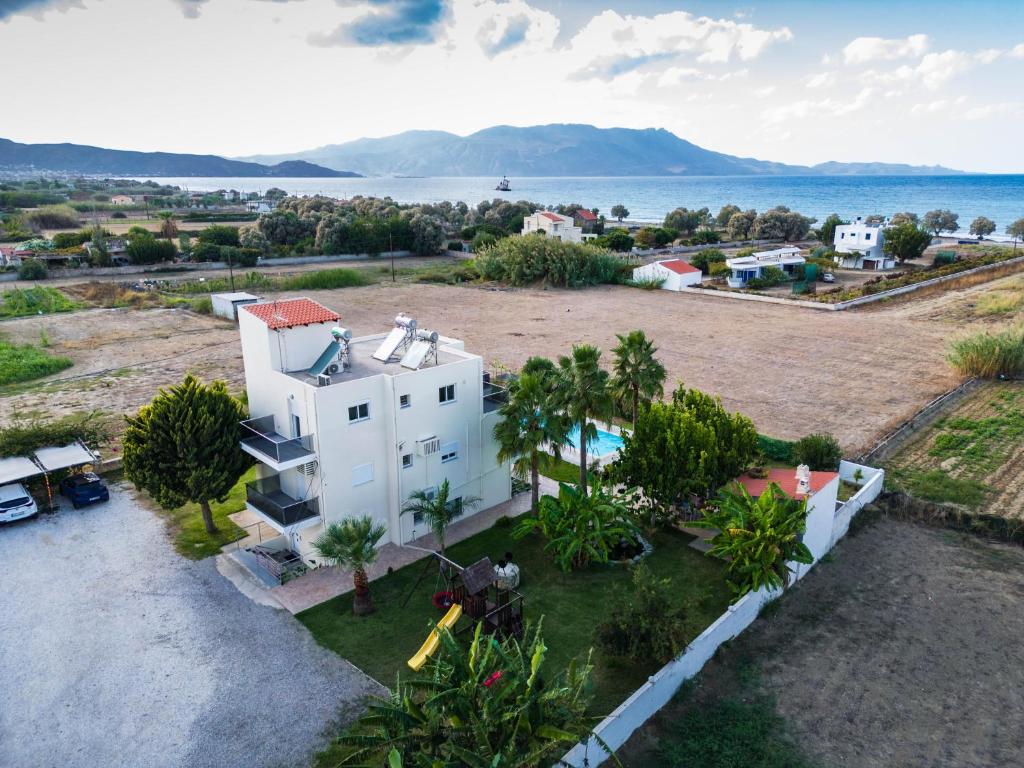 an aerial view of a white house with the ocean in the background at Martimi Private 3 Apartments with Pool, Heated Jacuzzi and Sauna, 2 Apartments with Sea View, 200m from Beach, BBQ, Playground, Mini Football Pitch in Kissamos