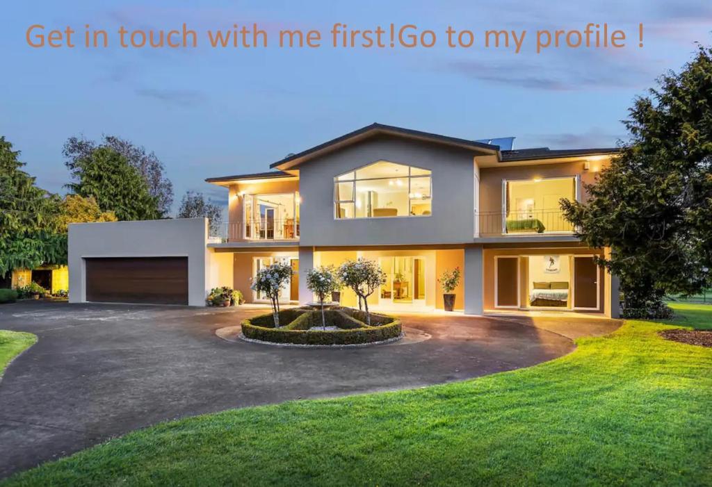 Una casa grande con entrada para autos con las palabras "Contáctame primero". en Lifestyle Living, en Huapai