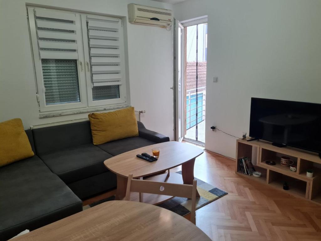 a living room with a couch and a table and a tv at Apartment California in Brčko